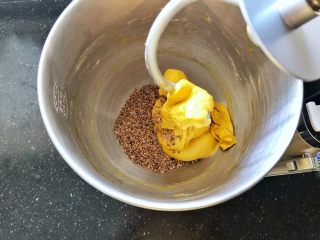 6、亚麻籽南瓜软欧包,6、倒入熟亚麻籽启动一档揉2分钟，将熟亚麻籽完全均匀的揉入面团中。