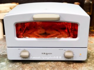 5、咖喱烤鸡翅_1557649375161,烤盘铺上锡纸，把腌制好的鸡翅摆放在烤盘上，送进烤箱230度烤15分钟，腌制鸡翅的碗中有腌料汁留着备用