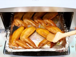 6、咖喱烤鸡翅_1557649375161,烤了15分钟，把烤箱拿出来，用刷子刷上腌料汁，鸡翅两都刷上，然后再次送进烤箱230度15分钟即可