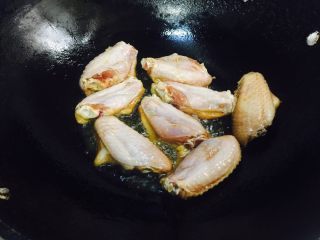 3、鸡翅焖饭,锅里加热放橄榄油，用小火煎鸡翅，煎至两面金黄。