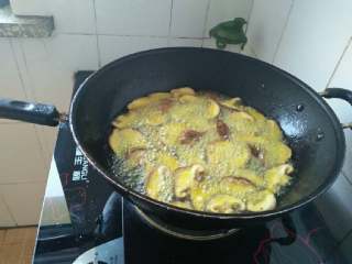 3、干煸香菇,锅内倒油烧热，下入裹好面粉的香菇过油至软；