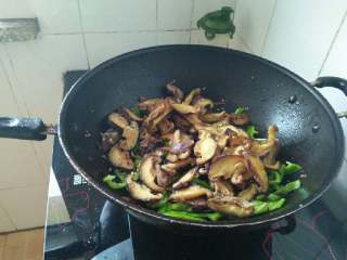 7、干煸香菇,倒入过完油的香菇，加少许盐和鸡精翻炒均匀；