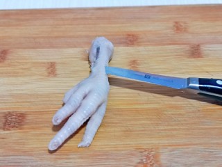 11、百香果柠檬鸡爪,泡好的鸡爪去骨，首先将根部用水果刀划断开，再鸡爪背上划一刀，如图。