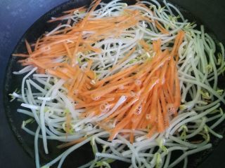 4、夏天来了，教你一招五分钟调制出爽口小凉菜,锅里放水烧开，然后倒入绿豆芽和胡萝卜丝，过水焯一下