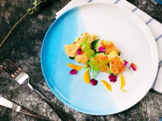 8、广式煎扒虾胶酿西兰花,把炒好的虾胶西兰花摆入盘中，点缀干玫瑰花瓣、向日葵花瓣、胡萝卜缨子即可