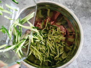 4、凉拌猪头肉,把擦好的黄瓜丝倒入猪头里。