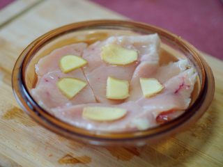 6、香辣秋葵手撕鸡,这样泡在料酒中，可以用生姜片涂抹肉，再放10-15分钟，等水烧开，可下锅煮