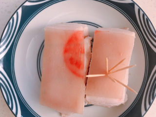 3、芋头扣肉,在皮上抹一点盐。然后用牙签在皮上戳孔。