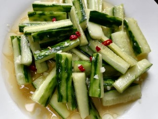 14、蒜泥黄瓜,放入辣椒，将热油浇在黄瓜上并搅拌均匀