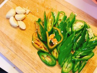 2、辣炒鸡肉,青椒对半切开，切成小块备用，大蒜切碎备用