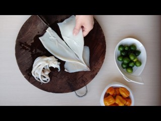 1、鲜辣酸柑鱿鱼,清洗好的鱿鱼从中间切开。