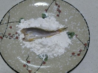 8、酥炸小黄花鱼,将腌制好的小黄花放到玉米淀粉中，让鱼肉表面沾满淀粉。