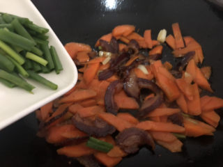 15、胡萝卜炒腊肉,再下葱叶翻炒均匀即可