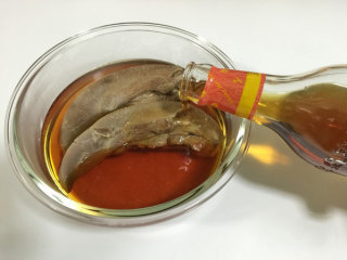 7、糟卤门腔,倒入糟卤至没过猪舌，盖上盖子浸泡，放入冰箱两小时