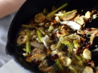 3、口水鸡,将锅里的热浸油倒入花生混合物中。把所有的东西都搅拌一下，然后用一个盘子盖住碗里的东西。 