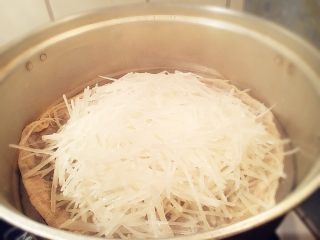 7、洛阳牡丹燕菜,泡好的白萝卜丝拌入绿豆淀粉，放入蒸锅蒸5分钟至透明状。