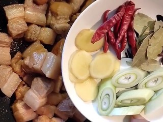 6、红烧肉,下入五花肉翻炒均匀，加葱姜，干辣椒，八角，香叶炒出料香味