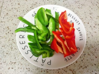 1、青椒炒鱿鱼,青椒和红椒去籽清洗干净切片