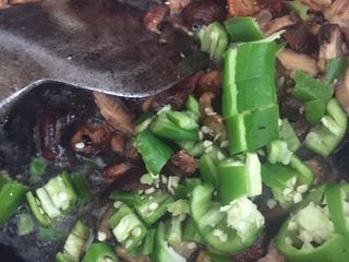 7、香菇炒肉片,再倒入青椒翻炒片刻，加入生抽，盐炒两分钟