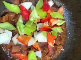 7、红烧牛肉,大火收干汤汁放青红椒，洋葱翻炒均匀出锅即可
