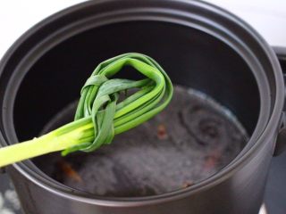 6、香卤鸡胗,把葱打结放入砂锅里。