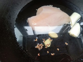 3、手撕鸡胸肉,凉水下锅，放入洗净的鸡胸肉，姜片，葱段，花椒粒