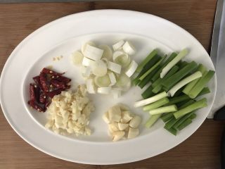 4、超下饭的油爆花蛤,干辣椒对半切，蒜瓣一部分切大块，一部分切成蒜泥，葱段切圈，小葱切长段。