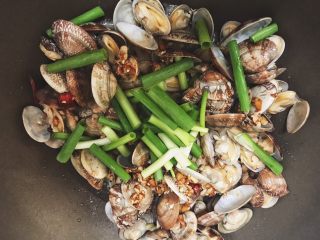 12、超下饭的油爆花蛤,关火，把小葱段放进去翻炒几下即可出锅。