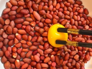 1、糖霜花生米,准备花生打入一个鸡蛋搅匀