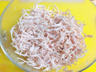 4、根本停不下来的★香辣烤鸡丝,时间到了之后，把肌肉捞出来，冷水泡一会儿，帮助其冷却。然后用手，把肌肉撕成丝，这个过程需要耐心，佳儿是大概撕了20分钟，也可以用俩个叉子，帮助你撕哦。不过我这个鸡肉太嫩了。叉子会扯断。我就手撕的。