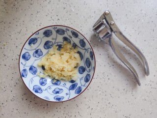 6、黄瓜拌腐竹,大蒜去皮洗净之后用压蒜器压成蒜泥，如果没有压蒜器，那就用刀切成末