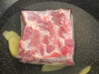 6、梅菜扣肉,把五花肉和姜片放入锅里，加入冷水，水量以盖过五花肉为准，大火烧开，转中火煮至肉熟透