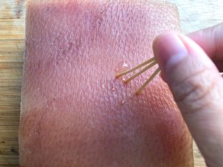 8、梅菜扣肉,五花肉煮好放到案板上，皮朝上，用牙签在肉皮上均匀的扎上小洞