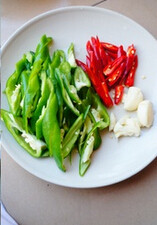 2、辣椒豆豉炒肉,青红椒中间破开切斜刀，蒜拍碎。豆豉洗干净用水泡好