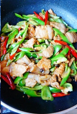 5、辣椒豆豉炒肉,加入泡豆豉的水一起大火翻炒至辣椒表皮变色，调入少量的盐、糖调味即可