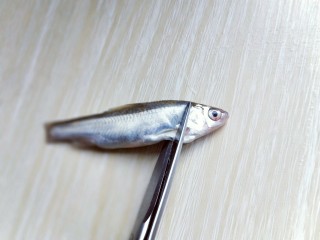 4、香炸小河鱼,再将鱼头剪掉，内脏清理干净，依次做完。