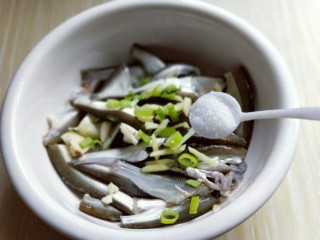 7、香炸小河鱼,洗干净的小鱼放入器具中，加入切好的葱姜蒜，再加入盐。