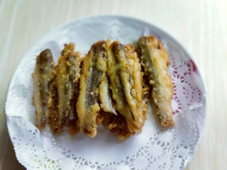 18、香炸小河鱼,炸好的小鱼两面金黄，放入油纸上吸多余的油腻，依次炸完，我的炸锅小，分批炸了4次。