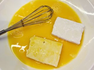 8、特制番茄酱煎豆腐,把鸡蛋打均匀，把沾满淀粉的豆腐，双面粘上蛋液