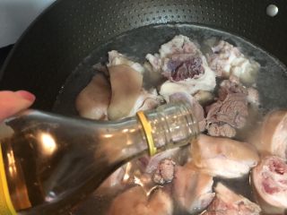 3、南乳猪手,锅内煮开水，放入猪手，倒入料酒去味，煮开变色后，即可捞起