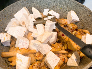 10、芋头烧鸡,再放入芋头块，翻炒均匀，再加入开水，盖过鸡肉，放入1勺盐，3根小米椒。盖上锅盖中小火炖25分钟，即可出锅