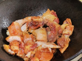 3、黄金小鲍鱼炆鸡(配靓汤套餐版),锅大火烧热落油,爆香姜蒜,放鸡下去。