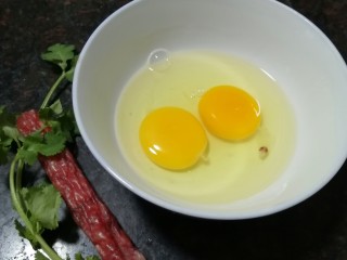 2、腊肠炒蛋,鸡蛋磕入碗里