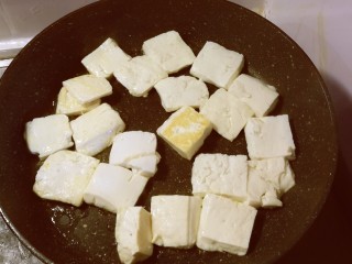 3、卤豆干,平底锅放入食用油加热，豆腐切块，放入锅中煎制。