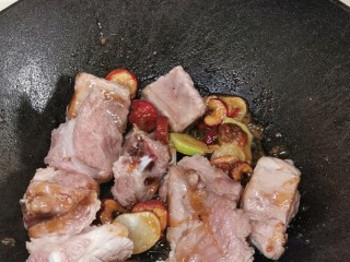 5、山楂小排骨,转大火，放入排骨，落料酒、老抽和生抽爆炒。