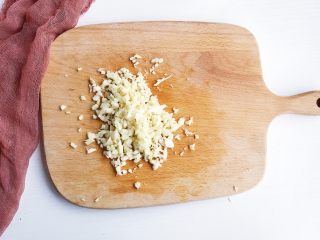 3、蒜蓉辣酱蒸扇贝,大蒜切末备用。