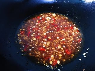 8、蒜蓉辣酱蒸扇贝,油锅烧热，倒入搅拌好的酱汁，最后加入适量清水焖煮一两分钟（调好的酱汁煮熟会更香，而且煮熟的大蒜味道不会呛口，颜色也不会发生化合反应，变绿影响成品颜值）