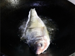 4、香辣豆瓣鱼,炒锅烧热,油多放一点,放入白鲢鱼炸熟;煮熟后,捞出控油,盛入碟子里;