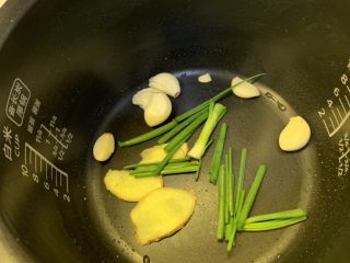 4、蜜汁烤鸡,把葱，姜，蒜，铺上去，然后放入鸡，按下煮饭键