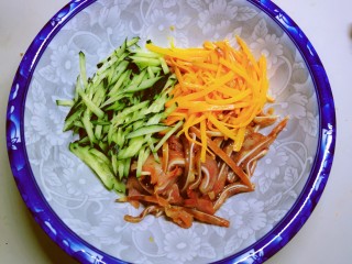 11、凉拌猪耳朵,黄瓜丝放到拌菜碗里